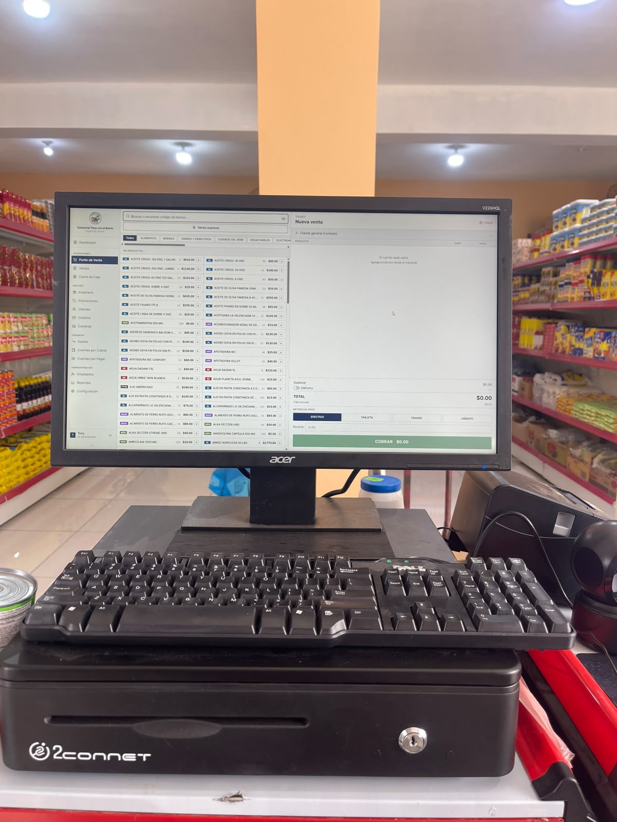 Punto de venta de JoFi abierto en el monitor de un colmado, sobre la gaveta de efectivo